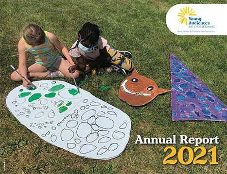 Young Audiences 2021 Annual Report Cover - students sitting on grass painting on cardboard