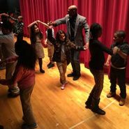 Marck "Flaco" Best dancing with students on a stage